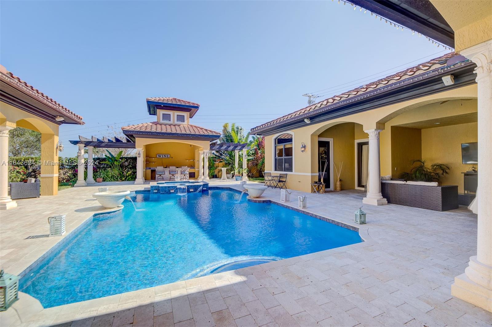 This Courtyard style home on 1.3 acreage was built for maximizing the views of the beautiful lake front property along with the spa like pool area. Welcoming entertaining areas for guests while maintaining separate private living areas for the residence. This beautiful home includes 5 bedrooms, 5 ½ bathrooms, guesthouse and an office. Additionally, there are over 2,000 SF of exterior living/entertaining areas which includes private lanais, covered patios, and an Oasis area with Wet Bar and