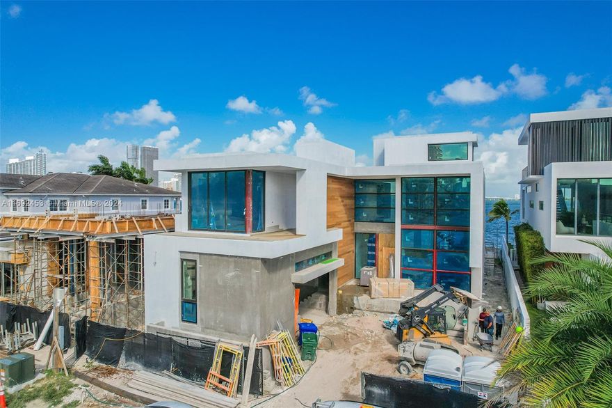 Experience luxury living in this extraordinary waterfront mansion in the Venetian Islands. This 6,370 sqft A/C, 9,785 sqft total space architectural gem features 6 bedrooms and 7.5 bathrooms, blending modern style with timeless elegance. Enjoy panoramic bay and skyline views that flood each room with natural light. A custom Italian kitchen offers premium Wolf & Sub-Zero appliances, wine cellar, and Porsche Technology lighting. Soaring double-height ceilings create spacious living areas perfect for entertaining. Outdoors features a summer kitchen, heated pool, and 60 ft of water frontage. Located on a quiet dead-end street. Completion May 2025. Built by Insignia Construction Company and developed by The Boschetti Group.