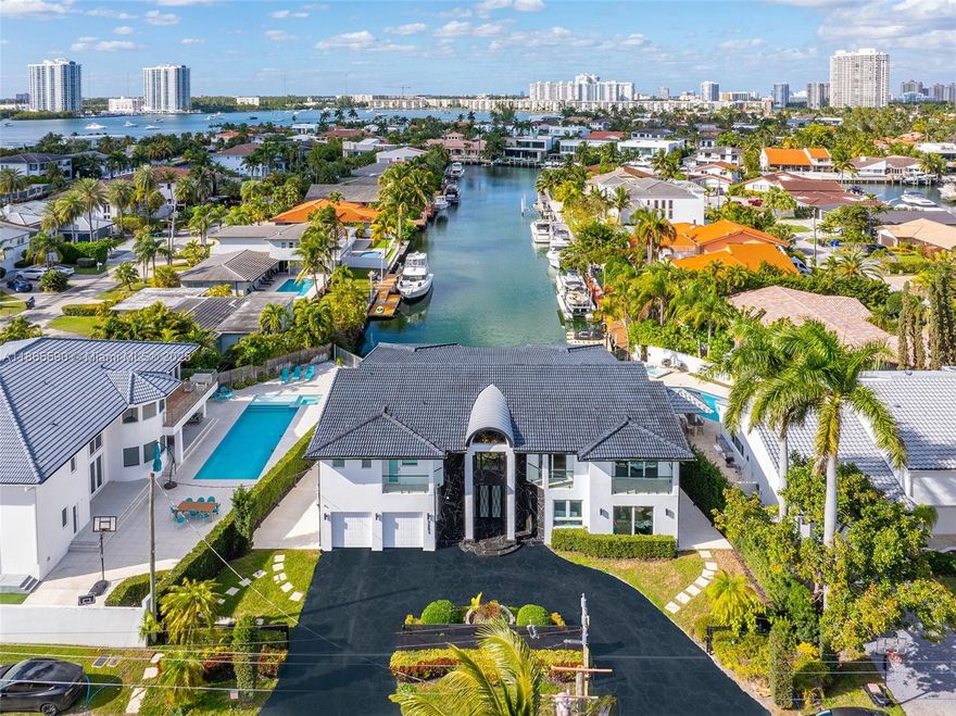 Epitome luxury waterfront house in the prestigious gated community of Eastern Shores. Boasting 5 spacious bedrooms, 4 lavish full bathrooms with soaring high ceilings. Architectural masterpiece offers a spanning 4,416 sq. ft. on 52 feet of prime water frontage. Panoramic canal views—unmatched privacy, no obstructing homes across water. Chef’s kitchen, top-of-the-line appliances, a seamless open floor plan, two magnificent master suites. Second floor features a sleek glass balcony and modern floating glass staircase, a contemporary flair. Spacious terrace, saltwater heated pool, jacuzzi and private dock, direct ocean access. Additional features a stylish front balcony, a sleek black modern security gate, large bar and entertainment room designed for ultimate unwinding experience.