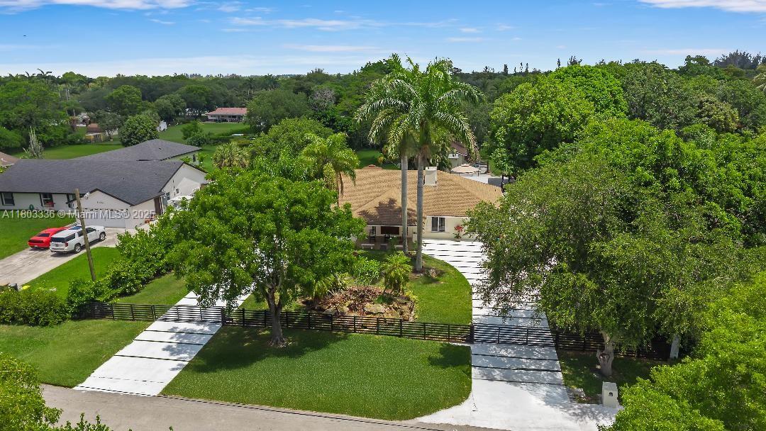 Welcome to your luxurious oasis! This stunning property sits on a private road, offering you the epitome of luxury, exclusivity, and privacy on a builder’s acre lot. Fully remodeled in 2024/2025. 5,558 sq ft, 6 bedrooms, 3.5 baths and new addition. Open kitchen design with island & quartz countertops, SS appliances, impact windows, vaulted ceilings, fireplace, guest house, garage, security cameras, putting green/playground, Heated Endless Pool with slide, two gazebos, electric aluminum fence, gym, home theater, commercial water purification, lush landscaping featuring 175-ft Royal Palms, 33,500 ft concrete driveway, carport, basketball court, double roof design with skylights 2016/2024, Enjoy a huge luxurious 700sf master suite with 2025 master bath and family room. Original owner