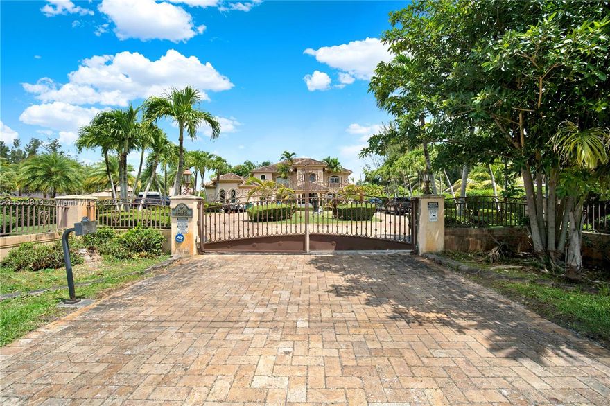 This custom-built home spans an impressive floor plan of 9,421 total s/f and includes a convenient elevator for easy access to all levels. Upon arrival, you're greeted by an elegant gated entry leading to a sprawling circular driveway, porte-cochere, and a spacious 3-car garage. The main residence boasts 6 bedrooms and 5.5 bathrooms, with an additional 1 bedroom and 1 bathroom in the expansive guest house/gazebo. Inside, the home exudes luxury with a family room, recreational room opening to a large balcony, and a gourmet kitchen featuring high-end stainless steel appliances and a center island perfect for culinary enthusiasts. Throughout the home, you'll find travertine marble floors, high ceilings, and high-quality impact windows.