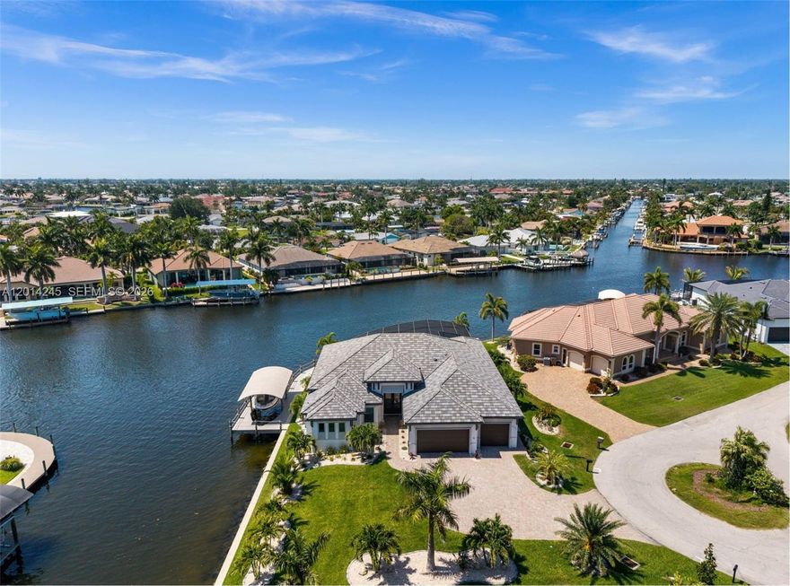AMAZING INTERSECTING CANAL VIEWS! BIMINI CANAL LUXURY HOME WITH 240 FEET OF WATERFRONT, DIRECT GULF ACCESS WITH NO BRIDGES, AND A PREMIER BOATING LOCATION! Welcome to this 2023-built showpiece at the end of a quiet cul-de-sac on an OVERSIZED .31 ACRE LOT. Positioned on the Bimini Canal with 200-foot-wide INTERSECTING CANAL views, this 3-bedroom + office, 3-bath home offers 2,683 sq ft, premium upgrades, custom finishes, and high-end details throughout.

The great room features coffered ceilings, designer lighting, premium flooring, linear fireplace, and 90-degree zero-corner sliders opening to the lanai, pool, and water views. The kitchen includes custom countertops, premium cabinetry, Sub-Zero and Wolf appliances, Wolf 6-burner gas stove, island, RO water filtration, and beautiful fixtures.

Outdoor living includes screened lanai, heated saltwater pool/spa, tanning shelf, paver deck, and outdoor kitchen with Bull gas grill, flat top grill, 2-burner station, Big Green Egg smoker, sink, and disposal. Two 120-gallon propane tanks serve the stove and outdoor 2-burner unit.

Waterfront setup offers a dock with 7,000 lb covered boat lift, water and electric on both docks, and a captain’s walk designed for a 40–44 foot yacht.

Features include 3-car garage, laundry room with built-ins, impact windows/doors, electric hurricane shutters and interior sun shades, 400 amp service, generator wiring prep, raised foundation, higher seawall, and landscaping. Near Bimini Square.