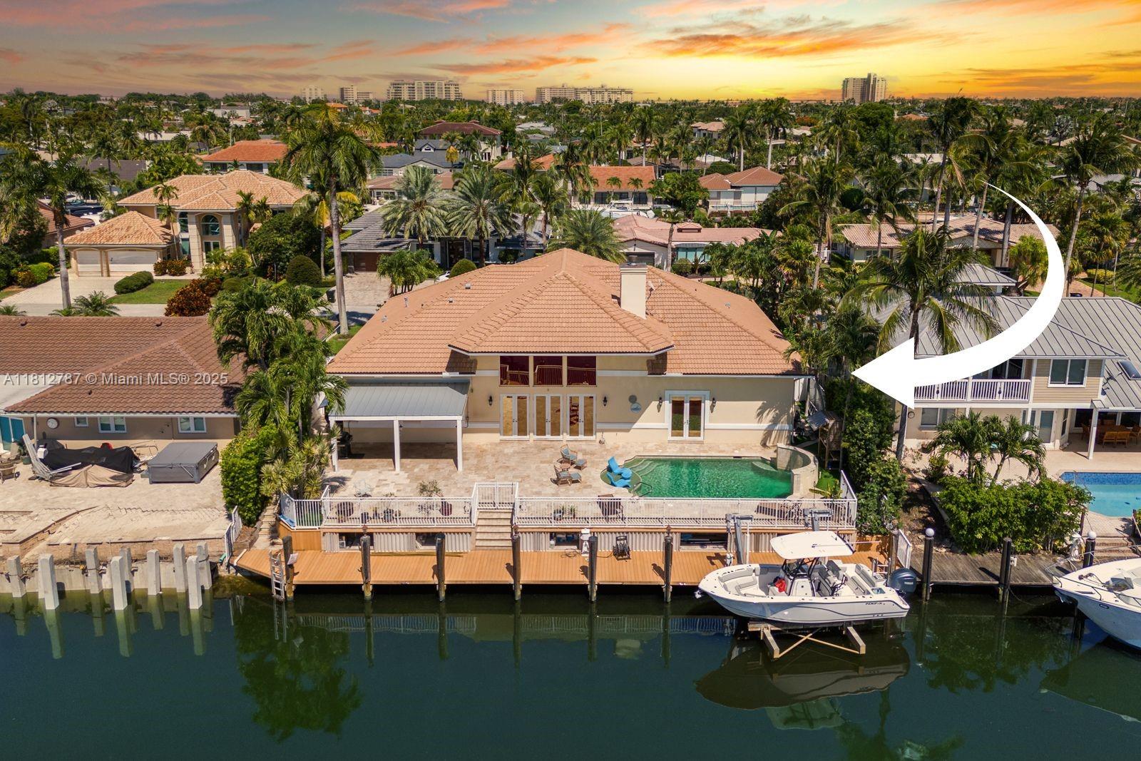 Experience water front luxury in Venetian Isles with this 4-bed, 3.5-bath custom home offering 90 ft of deepwater frontage with direct ocean access and no fixed bridges. Enjoy breathtaking sunrises and sunsets from the heated saline pool or through expansive impact windows. The interior boasts two primary suites, a loft/office, and an oversized attic for storage. The gourmet kitchen features high-end appliances and flows into open living spaces with a hidden Sub-Zero bar for entertaining. The composite dock includes water, electricity, and an ice maker, plus a 20,000-pound boat lift. Additional features: 3 A/C units, 500-gallon propane tank, and whole-home generator.