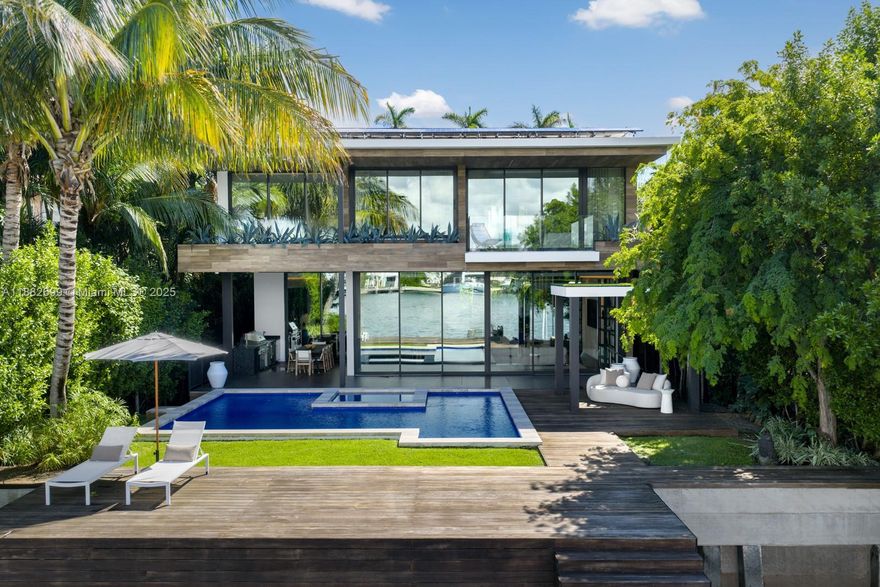 Waterfront luxury in this low impact Modern, meticulously designed by Max Strang, nestled in the prestigious Venetian Islands. This architectural combines sophisticated design with cutting-edge technology and unparalleled waterfront living. Featuring open-concept living areas, a sleek gourmet kitchen with custom Italian walnut cabinetry, and expansive floor-to-ceiling glass throughout. Offering 4 en-suite bedrooms, theater, elevator, Crestron smart system & Tesla solar integration. The primary suite includes private lounge, spa en-suite with Italian travertine and skyline terrace. Outdoors, enjoy a mosaic-tiled pool and spa, summer kitchen, rooftop terrace, private dock and 60’ of pristine Biscayne Bay access, presenting panoramic sunset views.