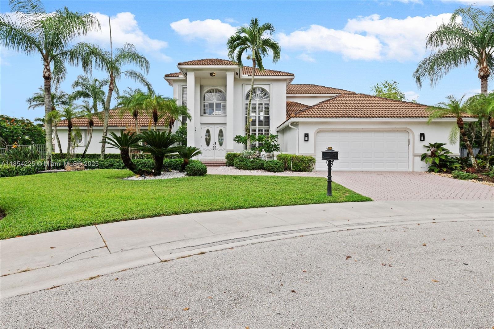 Welcome to this luxurious home featuring soaring ceilings, plantation shutters, French doors, modern stair railing, and accordion shutters. This 4-bedroom + den, 3-bath residence sits on an oversized 18,125 sqft fenced lakefront cul-de-sac lot in the Water Oak section of Weston Hills Country Club. The kitchen includes 42" wood cabinetry with full backsplash, & the upstairs primary suite offers a balcony with pool and lake views. All other bedrooms are downstairs. Enjoy a resort-style yard with pool, spa, tropical landscaping, and room to entertain or add a summer kitchen or playground. The 2.5-car garage includes a Tesla charger and golf cart space. Original builder floor plan (3,213 living sqft) is in MLS. Weston Hills is a gated golf community with parks and trails, zoned for A+ schools.