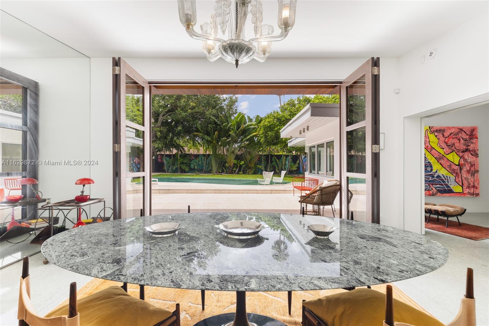 Discover classic elegance and modern comfort in this meticulously renovated mid-century modern home in Miami's coveted Morningside neighborhood. Nestled on an oversized 9,188SF lot, this 3BD/2BA architectural gem features original pistachio-hued Terrazzo floors, a Peetz mahogany front door, Bisazza mosaic tile bathrooms, and walnut cabinets and entryway lighting reclaimed from the Palm Bay Club. French-style double doors seamlessly connect indoor spaces to the private backyard and its recently retiled pool, new limestone deck, imported Ipe wood fence, and tropical landscaping that create an oasis for relaxation and entertaining. Located steps from scenic Morningside Park with tennis, playgrounds, and trails, and quick car access to MIA, Wynwood, Downtown, Brickell, and Miami Beach.