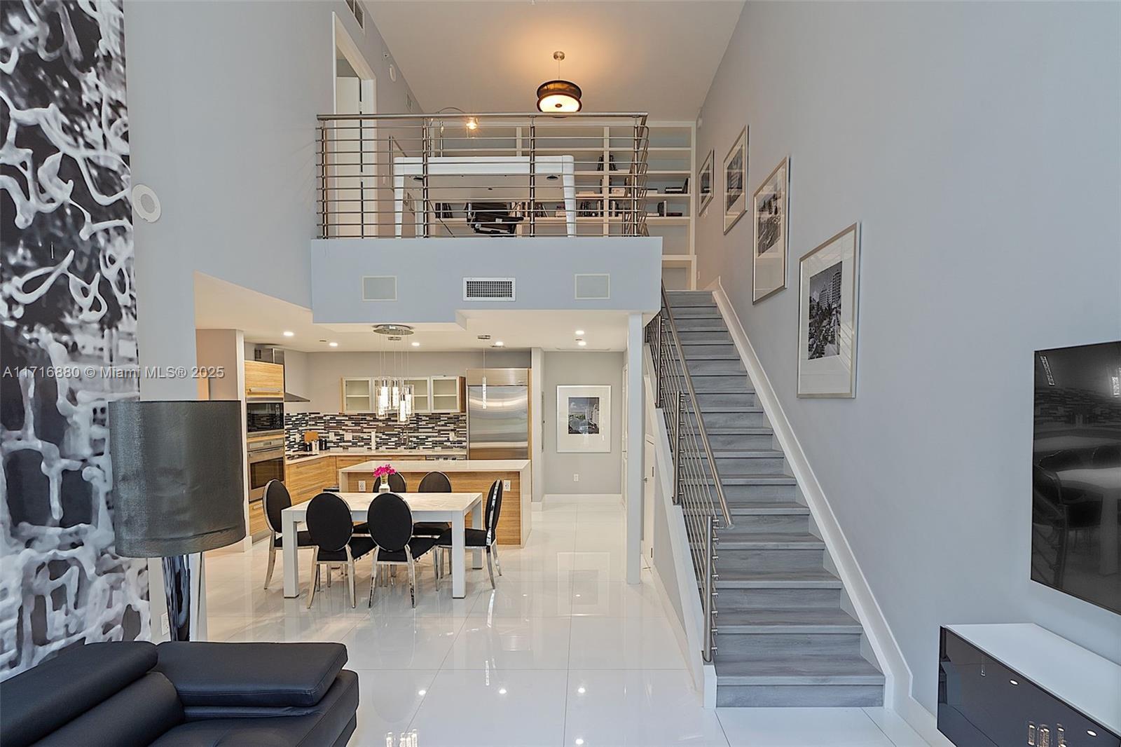 Turn key, furnished townhouse designed by Steven G. Perfect blend of autonomous living in comfortable luxury at Paramount Bay, one of the most desired buildings in Edgewater. Recently upgraded: storage space built below staircase, additional recessed ceiling lights in the kitchen and wood laminate on stairs replaced the former carpet, electric blinds downstairs. Two-story, 20+ foot living room ceilings. Guest bedroom & private bathroom downstairs, master bedroom upstairs with loft balcony, huge den area, spacious walk-in closet. Subzero & Wolf appliances, wine chiller, full size washer & dryer. Unit has a covered parking space. Amenities @ Paramount Bay include 2 pools, gym, spa, valet, cabanas, bonfire area and more. Wi-fi & cable included. It can be sold furnished or unfurnished. Pets ok