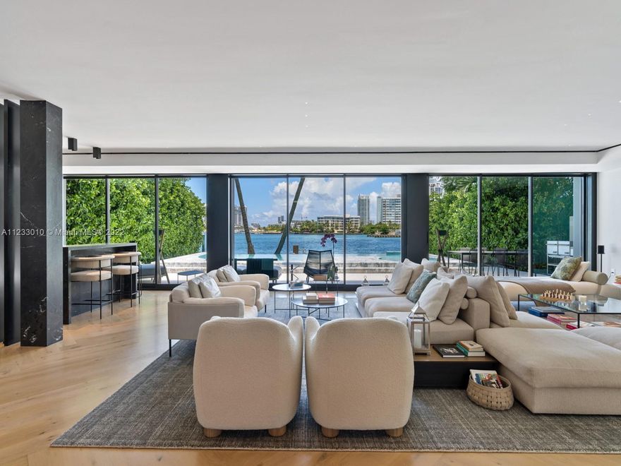 Completed in 2021, this resort-style contemporary home on Rivo Alto, the most desirable of Miami Beach’s Venetian Islands, is highlighted by a dramatic pool and spa, clad in Statuario marble and lined in transparent acrylic facing the fine Ipe wood dock and eastern Biscayne Bay views. Various expressive marbles highlight the open-plan living area, with its elegant cocktail bar, sweeping sculptural staircase, retracting glass doors, and masculine chef’s kitchen, well-equipped with Gaggenau appliances and mirrored Italian cabinetry. The home offers six bedrooms, a discreet staff suite, a lavish master bath by Boffi, a massive master closet, and a third-floor roof deck large enough to entertain in style, while streetside, lush landscaping enhances the drama of the entry approach.
