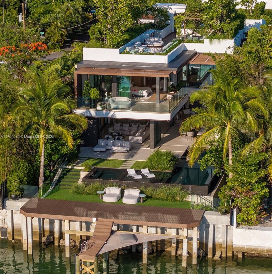 AWARD-WINNING—Maison Rive Gauche, crowned Best Luxury Architecture in Florida for 2025, is a bold waterfront masterpiece by Strang Design, capturing the essence of refined living on the Venetian Islands. Thoughtfully designed with sophistication and attention to detail. A tranquil water garden arrival sets the tone for brilliance. A 22’grand salon wrapped in oak-paneled walls features a bespoke bar, 420-gallon aquarium, and sunset lounge. The Gaggenau kitchen impresses with sculptural oak island and sleek cabinetry. The 1,400 SF primary suite offers dual spa baths, 2 walk-ins, and skyline terrace. 4 ensuite bedrooms, theater, office, elevator, and a panoramic rooftop, designed for comfort and ease, with stunning sunset views, perfect for entertaining. A/C garage, seawall, and 2 boats dock.