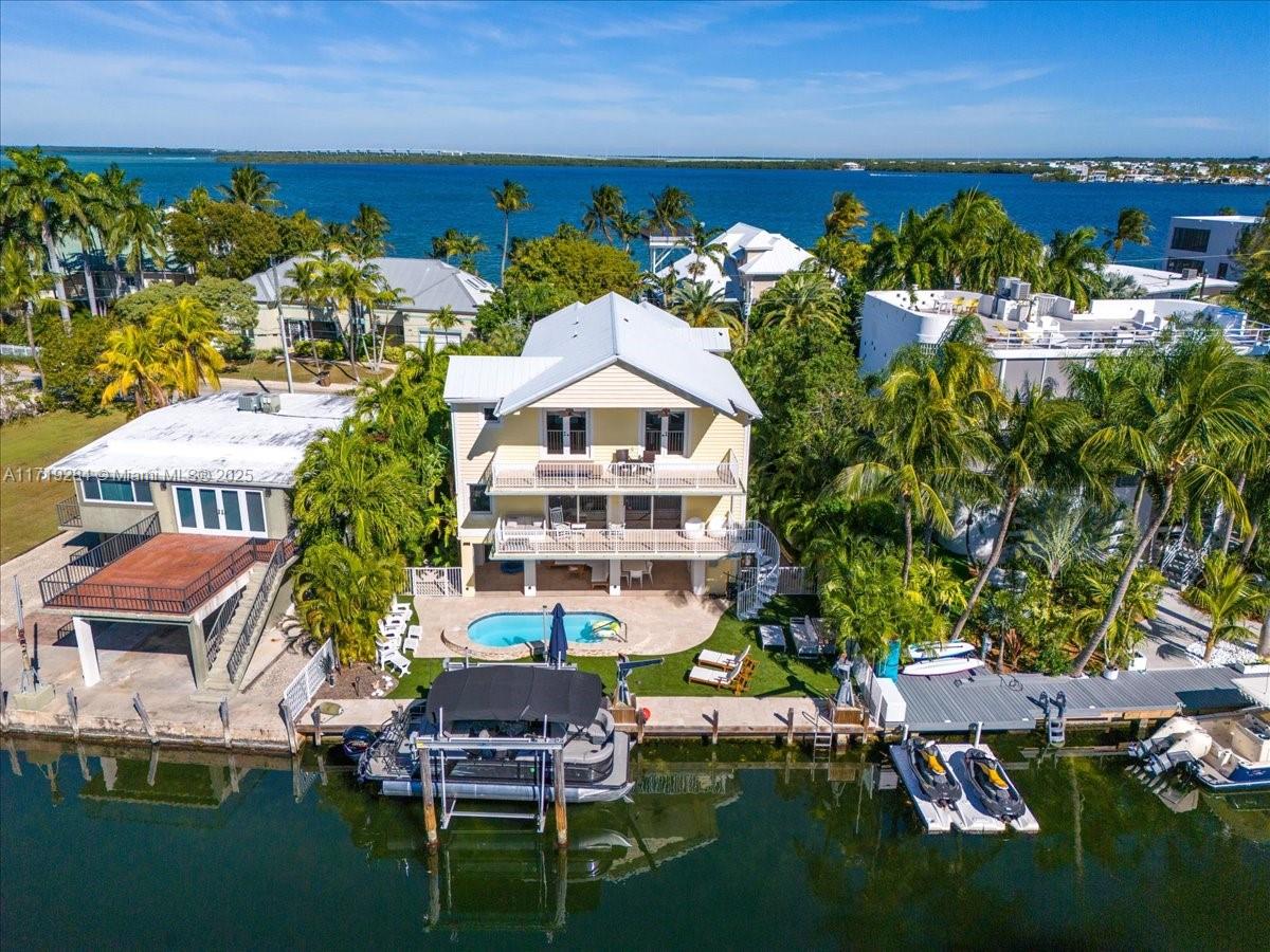 Newly renovated waterfront home offers seamless indoor/outdoor living w/ 60 ft of waterfront frontage. Spacious terraces offer stunning sunrise & sunset views w/ vistas of the canal & open bay. Open-concept living area fills home w/ natural light & the gourmet kitchen is equipped w/ top-of-the-line Italian appliances & a large island perfect for entertaining. Oversized primary suite w/ high vaulted ceilings, walk-in closets, & a spa-style marble master bath w/ an oversized shower & soaking tub. Media room can easily be converted to a 4th bedroom. Outside, enjoy your private oasis w/ a beautifully landscaped yard, private dock, 2 boat lifts, saltwater swimming pool, & a cabana bathroom. Extras include a video security system, recessed lighting, private elevator, & an electric car charger.