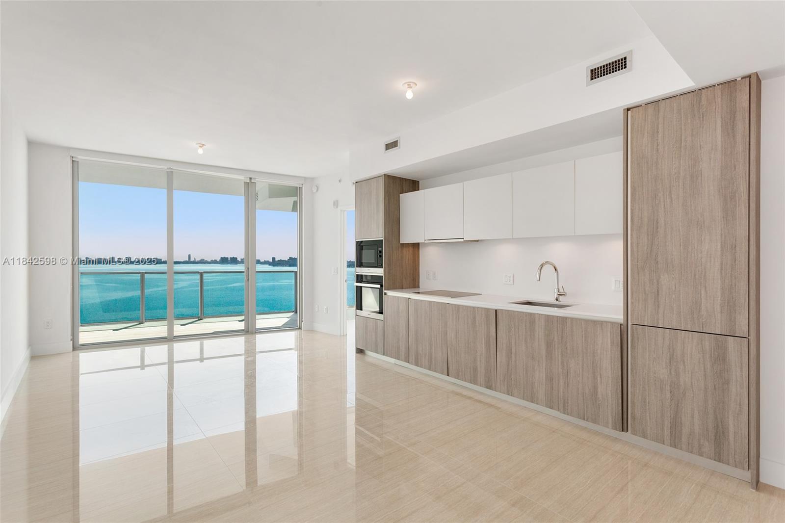 Stunning 2-bedroom, 2-bath residence at Biscayne Beach Condo with soaring ceilings and floor-to-ceiling windows offering breathtaking panoramic views. Enjoy ultimate privacy with private elevator access. High-end finishes include quartz countertops, Miele appliances, and custom cabinetry. Porcelain tile floors and built-out closets complete this impeccable home. The building offers exclusive amenities: a fitness center overlooking Biscayne Bay, private pool and hot tub, spa with treatment rooms, 2 tennis courts, residents-only dog park, and social rooms. Luxury living at its finest!