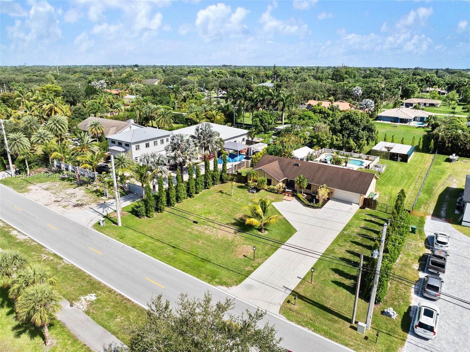 Discover this exceptional opportunity to own a beautifully maintained 3 BED / 2 BATH home situated on a true builder’s acre in one of Davie’s most desirable areas – just minutes from Southwest Ranches. Surrounded by lush, mature landscaping, this serene property offers privacy, space, and flexibility for RVs, boats, horses, or future expansions. Spanish tile flooring throughout, a stylish kitchen with granite countertops, and impact windows for peace of mind. Step outside into your personal oasis – a huge covered patio ideal for entertaining, overlooking a sparkling pool and expansive green space.