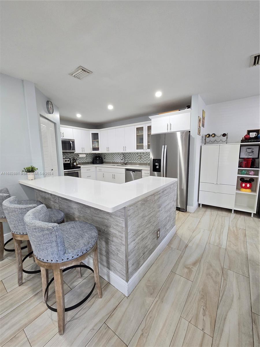 Discover comfort and style in this spacious open-concept 3-bed, 2.5-bath corner townhouse in Visions of Bonaventure. The first floor features a remodeled kitchen with granite countertops and stainless steel appliances, a family room, an enclosed sunroom with impact windows, a convenient half-bath, tiled flooring, extra storage under the stairs, and a tankless water heater. The second floor, with laminate wood flooring, includes three bedrooms, a master bedroom with a walk-in closet, and remodeled full bathrooms. Enjoy two dedicated parking spaces, a community pool, A+ schools, and full membership to The Bonaventure Town Center Club, which offers pools, mini golf, tennis, bowling, a fitness center, and special events. This townhouse combines style and functionality—schedule a viewing today!