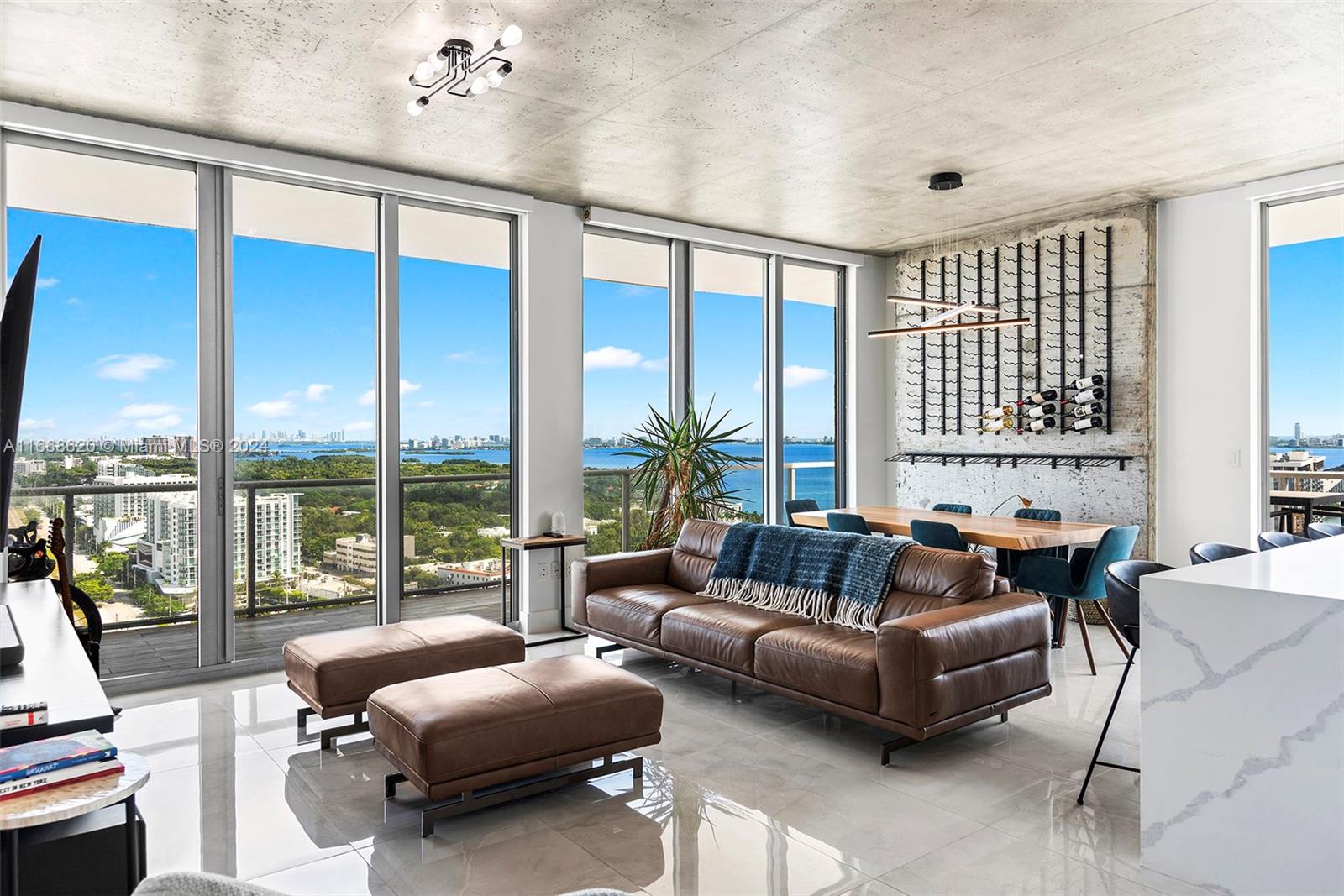 Renovated with style, this 3-bedroom, 2.5-bathroom NE corner residence on a high floor at 2Midtown, offers breathtaking views of Biscayne Bay and the Miami skyline. With over 2,200sf of meticulously remodeled living space, this home features a custom two-tone kitchen with quartz waterfall island, upgraded bathrooms with Opustone walls, and a Hansgrohe shower system in the primary bath. Designer doors, restored concrete ceilings, and oversized Parmesa Ceramica tiles add to its charm. The expansive 672sf wraparound terrace offers captivating views. Luxury amenities include a fitness center, pool, spa, sauna, concierge, and valet parking. Two parking spaces are included, and the vibrant midtown area offers the best shopping and cultural experiences right outside your door.