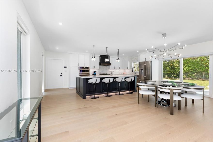 Step into unparalleled luxury with this fully remodeled 4-bedroom, 4-bath home on a half-acre lot in a tranquil, park-like setting. Designed for modern elegance and effortless entertaining, the residence features two expansive primary suites, perfect for multigenerational living or pampered guests. Sunlight streams through impact hurricane windows, while a metal roof and new A/C ensure comfort and peace of mind. Gleaming engineered wood floors flow throughout, complemented by new PVC waste lines and high-end finishes.

The gourmet chef’s kitchen is a true centerpiece, with custom cabinetry, a dramatic 10-foot quartzite island, a designer vent hood, two dishwashers, two refrigerators, and dual ovens—one gas, one electric—ideal for hosting family and friends. Bathrooms shine with premium Toto toilets, including two with bidets. Every room offers custom closet organizers and electric blinds, while EV-ready infrastructure adds modern convenience.

Outside, enjoy a newly refinished Diamond Brite pool framed by lush landscaping, with an automatic sprinkler system maintaining the grounds. This home effortlessly blends indoor elegance with outdoor living, offering a private oasis that embodies upscale South Florida lifestyle. Move-in ready and crafted for those who appreciate sophistication, comfort, and entertaining at the highest level.