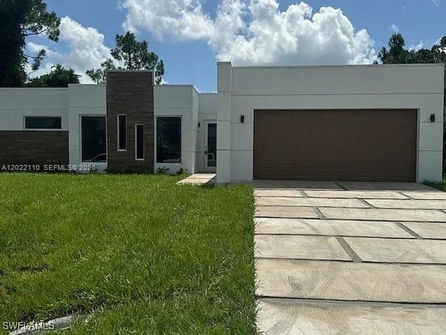 Seller financing available.  Lease option or lease purchase also available.  Custom-Built Masterpiece in Prime Lehigh Acres Location. Discover a one-of-a-kind, custom-built contemporary home featuring 3 spacious bedrooms and a luxurious master suite complete with a generous walk-in closet and a spa-inspired bathroom. The master bath offers a glass-enclosed shower and dual sinks for added convenience. An additional half-bath ensures guests are comfortably accommodated. Enjoy seamless entertaining in the open-concept living and dining area, which flows effortlessly into the chef’s kitchen. This culinary haven includes white 42? Shaker-style cabinets, high-end stainless steel appliances, and a striking waterfall quartz countertop island. Car enthusiasts and DIYers will appreciate the oversized garage with a dedicated tool room and built-in storage. Step outside to the patio, perfect for evening barbecues and stylish entertaining. Situated in a sought-after area of Lehigh Acres, this unique home provides easy access to shopping, dining, and everyday amenities. With modern design and thoughtful craftsmanship throughout, this home truly stands apart.