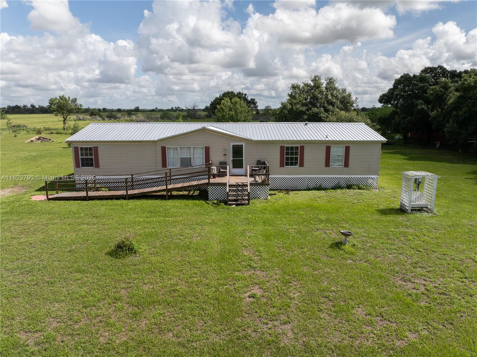 ENJOY COUNTRY LIFE'S CLEAN AIR AND TRANQUILITY! PEACEFUL PROPERTY BACKS UP TO LARGE PASTURE LAND FOR MAXIMUM “COUNTRY QUITE” LIVING! Great .628 acre tract with lovely trees, a 22x66 4 bedroom, 2 bath doublewide mobile home boasting a brand new, just completed, galvalume metal roof. Home enjoys a ramp to the front open “rocking chair” porch, a fireplace and real wood deck/open porch. Property also features a large storage/garden shed and a covered picnic pavilion for those family gatherings in the Florida sunshine! Primary suite combines a huge bedroom with oversized bathroom and walk-in closet. Guest bedrooms are on the east side of the home and include the guest bath. Home living consists of a large living room with kitchen, separate laundry, dining room and family room.