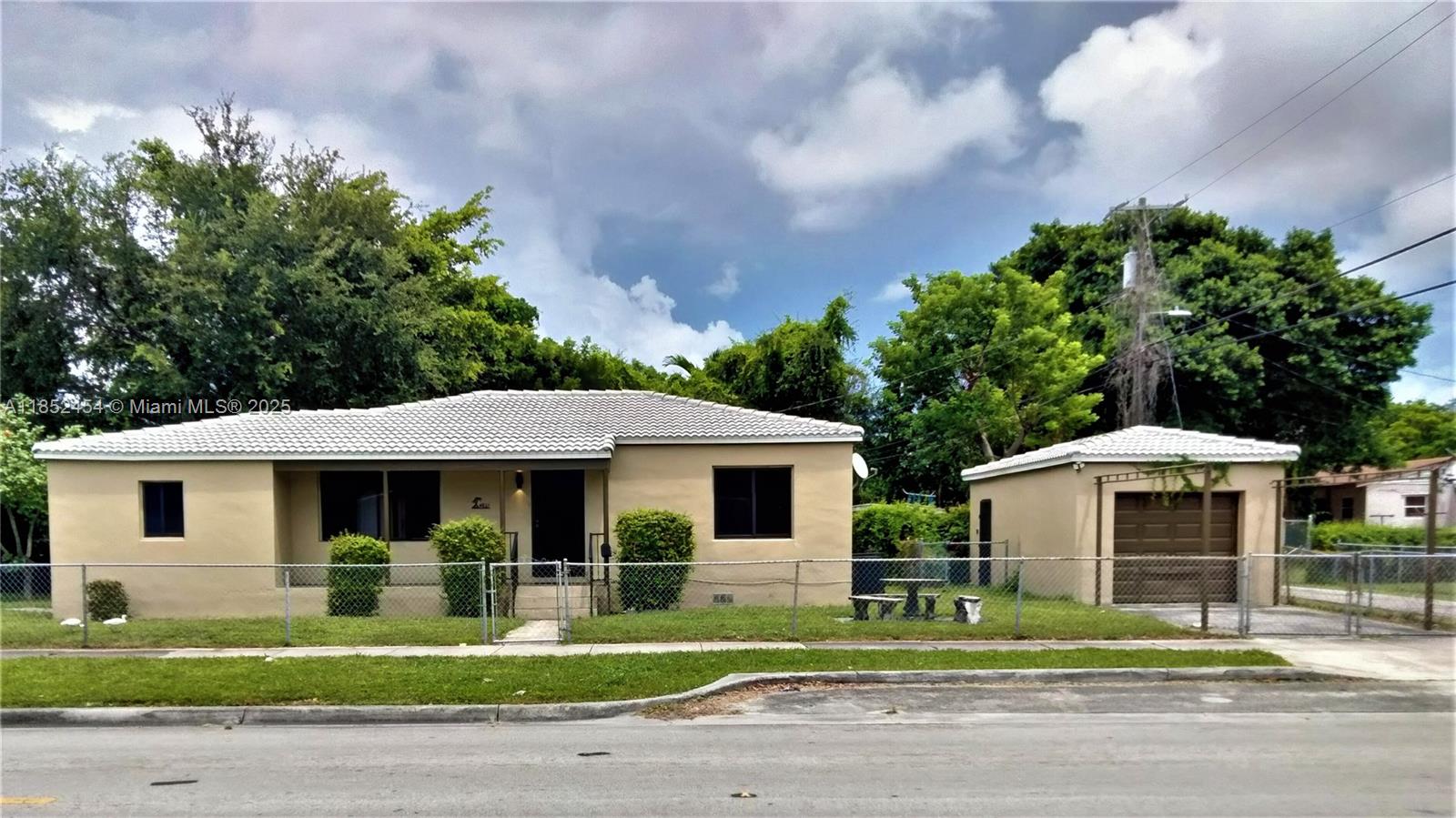 Large 4/2 home 1,400 SF & a detached 325 SF garage w/ plumbing & electric. Add drywall & AC to turn the garage into a home office, gym or more living space! NW bedroom has a separate entrance & en suite bath. Home could be used as a single family 4/2 or use the north side as a separate in-law apartment. Covered front porch, laundry hook ups, central AC & heating, recessed lights, a new tile roof, new impact windows, new LVP flooring, lighting & electrical upgrades. Enjoy as-is or renovate kitchen & baths. Corner lot is fenced & there is gated parking for one car in the d/w, one car in the garage, plus free street parking. Property is within a Qualified Opportunity Zone & ROI is 6%-13.5% depending on how the rentable space is subdivided or improved (please see pics for ROI analysis.)