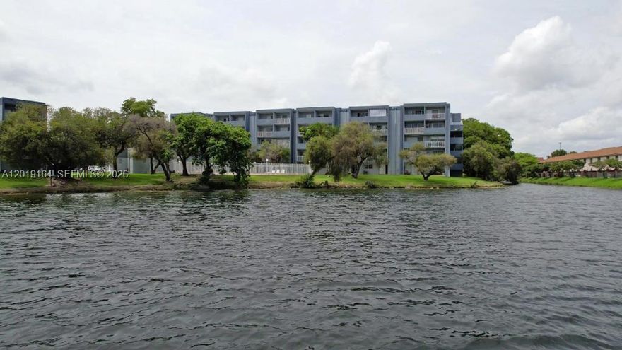 Wake up to breathtaking lake views and unwind to shimmering pool vistas from your private balcony. This bright, beautifully finished residence features sleek porcelain tile throughout and an open, sun-filled layout designed for effortless Miami living.

The showpiece kitchen impresses with rich granite counters, a center island, stainless steel appliances, and crisp white cabinetry with stylish glass-front uppers. The bedroom offers a built-out walk-in closet, and a versatile extra space with closet works beautifully as a den, home office, or guest room. In-unit laundry.

Resort-style guard-gated community: pool, tennis, playground, elevator, and a private sand beach with loungers along the lake. Minutes to shopping and dining. Some photos virtually staged. Schedule your tour today!