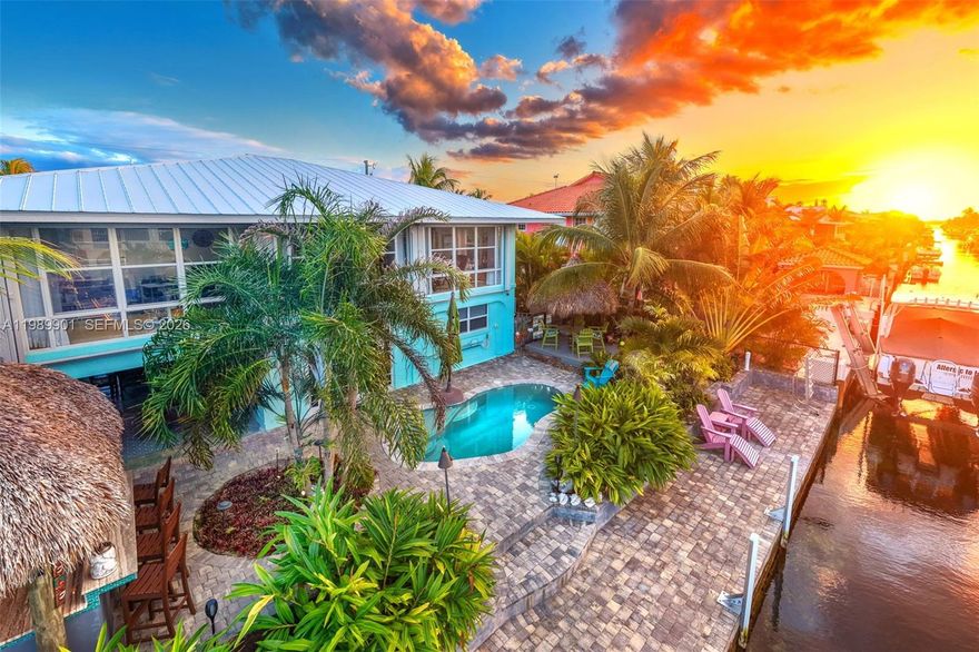 Looking for your piece of paradise in the Keys? You've found it! This property feels like a lush private resort. The exceptional features include pavers on deck and dock, heated/chilled pool, tiki hut and tiki bar, chef's outdoor kitchen, 10k boat lift, landscape irrigation with separate water meter, and landscape lighting. The entire yard is fenced and gated. The 1596 sq. ft. concrete block home is very bright and light with hardwood and travertine floors. Floor-to-nearly-ceiling height windows in the large sunroom create a wonderful sitting room and office. A focal point in the kitchen, the stunning oak table island provides storage and seating for 6; stainless steel appliances include a chef's oven and 5-burner gas cooktop. The primary bedroom has a large closet, armoire and renovated ensuite bath with a tiled shower and tile inset shelf, customized vanity and wood tile floor. Also renovated, the second bath includes a bathtub with a tiled surround and inset shelf. On the ground level are the garage and storage enclosure with a convenience bath and ice machine hookup, and an inviting sitting area for relaxing and entertaining. The upstairs windows are impact-resistant except for the sunroom windows which are protected by accordion shutters. Additional features include a 20KW whole house generator, passenger elevator, paver-drive. Don't hesitate - this won't last long!