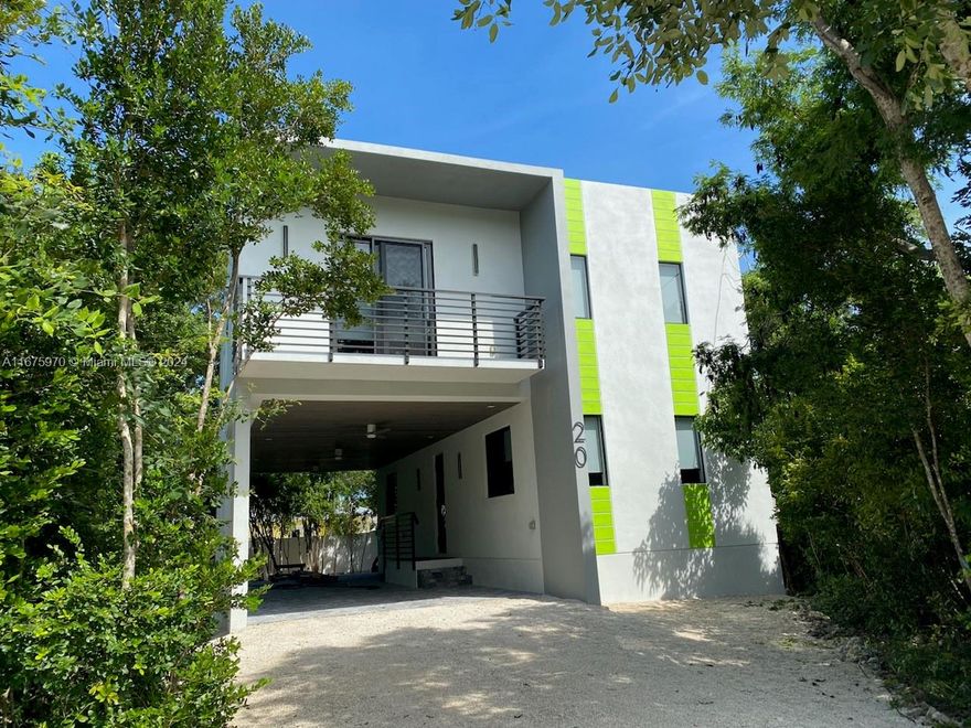 New Modern Living. This is a 2024 new never been lived in property with solid concrete walls and roof. Full impact doors and windows with high elevation providing safety for storms and hurricanes. House has five bedrooms with three bathrooms for your family. Three bedrooms and two baths upstairs with 8-foot ceilings and doors with laundry room. LED lighting with high ceilings to accent the beautiful quartz counter tops. Island stove/oven with ample seating. A large covered terrace to enjoy the outdoors. Outdoor kitchen for your pleasure. Separate two bedrooms on the first floor with a full bathroom and much more. Two covered parking spaces with a decorative vaulted beautiful ceiling. Property has mature trees surrounding this gem for your privacy. Walk to the restaurants, shops and marina.