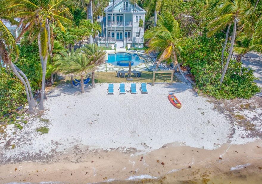 Enjoy endless ocean views and direct access to the white sandy beaches of Islamorada from this oceanfront retreat. Behind your own private gated entrance, this solid concrete block home offers four bedrooms, four full bathrooms, and a cozy loft. Inside, hardwood floors run throughout an open layout featuring a breakfast nook, dining bar, and spacious living area — ideal for entertaining. The chef's kitchen is equipped with stainless steel appliances, a gas stove, and modern finishes. The master suite includes a private balcony overlooking the updated saltwater pool and a jetted tub for ultimate relaxation. This one-of-a-kind property also allows weekly rentals, making it a strong investment in one of the Keys' most sought-after locations.