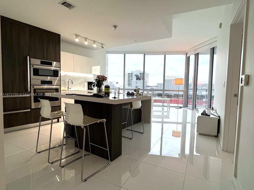 Bright and light 1 BD + DEN apartment with 2 FULL baths, and vast balcony. Private elevator with only your hall, spacious den (with a bunk-bed) and the closet. Huge walk in closet in the master bedroom with king-size bed. Unit goes with 1 assigned parking spot + valet. Stunning amenities in Paramount building - several pools (with skydeck pool), lounge areas, spa, fitness with boxing area, yoga studio, tennis courts, soccer field, cinema room, game room, children area, summer kitchen with BBQ, bar, even food market in the building and many more. Convenient location - walking distance to Bayfront Park, FTX Arena, Perez Art Museum and park and cafes, 2 mins to metromover. Close to NIU restaurant, Novikov, Zuma etc. New TV is in the living room. AVAILABLE for 1 year starting October 28, 2024