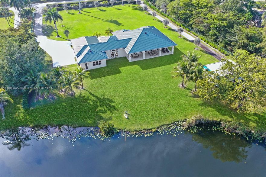 Exquisite 2021 custom-built modern compound on 2 gated acres w/private lake. Main home: 4BD/4.5BA/4,038SF Living. Highlights: Grand foyer, soaring 12ft ceilings, open living/great room, chef's kitchen w/quartz waterfall island, 48"x48" porcelain tile, all bedrooms w/ensuite bath & walk-in closet. Guest House: 1BD/1BA/660SF w/living, kitchenette + flex space for office/gym/storage. Spacious covered outdoor living. Expansive grounds for pool, sports courts, equestrian. Oversized garage w/epoxy floors, custom cabinetry, workshop & space for lift. 2 driveways-room for boat/RV. Smart, secure & efficient: impact windows/doors, foam-insulated concrete, dual AC, metal roof w/solar vents, 7-camera security, solar motorized gate. HOA $200/yr, no restrictions. Design Services Included for 4 rooms!