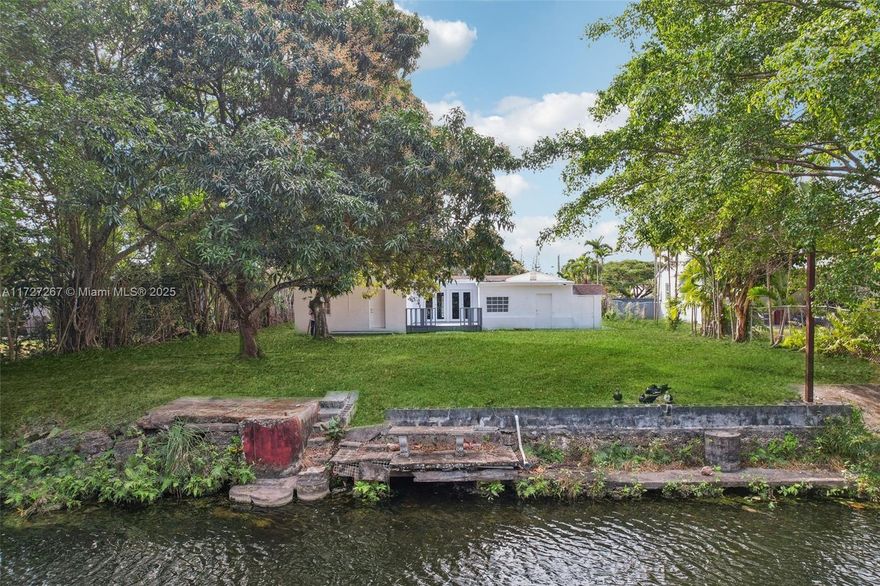 This stunning 3-bedroom, 2-bathroom waterfront home spans over 2,400 square feet and sits on an oversized lot with its own private boat ramp. Designed for entertaining, the home features a bright, open layout with abundant natural light and a sprawling outdoor space complete with a wooden deck. The lush landscaping includes mango, lychee, and other fruit trees, with ample room to add a pool or spa. Move-in ready, the property boasts a brand-new kitchen, updated flooring, a tankless water heater, and a circular driveway with automated gates. Conveniently located just minutes from I-95, hospitals, and popular dining and shopping spots, this home blends comfort, style, and accessibility seamlessly.