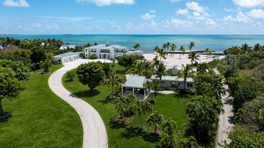 A rare dual-parcel offering on prestigious Millionaire’s Row in Tavernier, 88835 and 88845 Old Highway present an extraordinary opportunity to own one of the Upper Keys’ most expansive and versatile oceanfront compounds. Spanning multiple acres with 480 feet of waterfrontage, the property combines exceptional privacy, premier boating access, and remarkable future development potential. At 88845 Old Highway, a newly constructed 8,200 SF modern estate showcases 5 bedrooms, 6 full baths, 2 half baths, designer finishes, smart-home technology, a resort-style 120-foot pool, and a protected basin with dockage, boat lift, and deep-water access. Complementing the main estate, the adjacent parcel at 88835 Old Highway encompasses over 3 additional acres and introduces a rare layer of flexibility and long-term value. The property includes a renovated 3-bedroom residence completed in 2022, a transferable TDR allowing for the future construction of a substantially larger primary residence, an additional buildable lot, and a lush natural hammock buffer that enhances privacy and exclusivity. Together, this exceptional compound delivers an unmatched blend of luxury living, investment potential, and future flexibility in one of the Florida Keys’ most coveted waterfront settings.