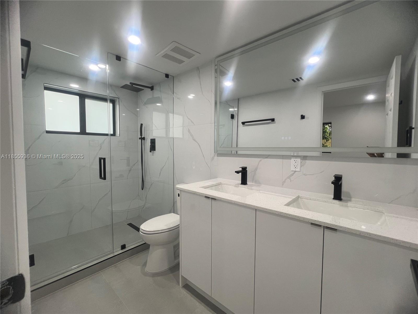 Stunningly renovated home featuring a modern kitchen with glossy white cabinets, quartz countertops, and full stainless-steel appliance package. Enjoy the elegant backsplash, under-cabinet storage, and contemporary black faucet. Spacious laundry area with washer and dryer included. Sleek tile floors flow throughout, creating a fresh, bright, and open atmosphere. Perfect for those seeking style, comfort, and move-in-ready convenience. With a lot size of 7,700 Sq.Ft there is plenty of space for a large boat, an RV or both.