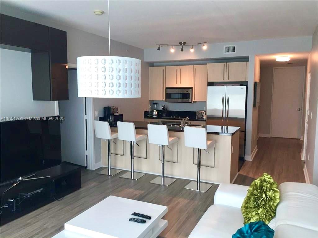 Furnished Upper Penthouse at Axis on Brickell! Spacious 2BR/2BA + Den/Office split layout, floor-to-ceiling impact glass, and a wide balcony accessible from every room offering skyline views. Open kitchen with modern finishes, ideal for entertaining. Includes 2 assigned parking spaces. Located in the heart of Brickell, steps to Brickell City Centre, restaurants, shops, and financial institutions. Full-service building with 24/7 front desk, valet, infinity pool, BBQ area, sauna, gym, business center, large clubroom with games and bar, and more. Luxury high-rise living in one of Miami’s most walkable and vibrant neighborhoods! -- CLICK ON VIRTUAL TOUR!!--