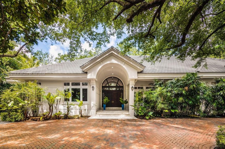 Exceptional Custom One-Story Tropical Sanctuary in Pinecrest on an acre! This 6 BD / 5.5 BA, 7,345 Total SF Estate seamlessly integrates expansive interiors w/ an outdoor oasis. Double mahogany doors open to voluminous ceilings & MQ transom windows providing views of lush landscaping from every room. Gourmet kitchen boasts a breakfast nook w/ views of the resort style pool & backyard, large island, & 146-bottle wine fridge that leads to a large vaulted-ceiling family room w/ wet bar. Entertain under the screened patio w/ fully equipped summer kitchen. Separate guest quarters w/ full bath. Primary suite w/ 2 walk-in closets, seating area, lavish bath, & screened porch. 4 addt'l bdrms w/ high ceilings & walk-in closets (2 en-suite). 3.5 Car Gar, 40 kw Generator, Pinecrest Elem. School Zone.