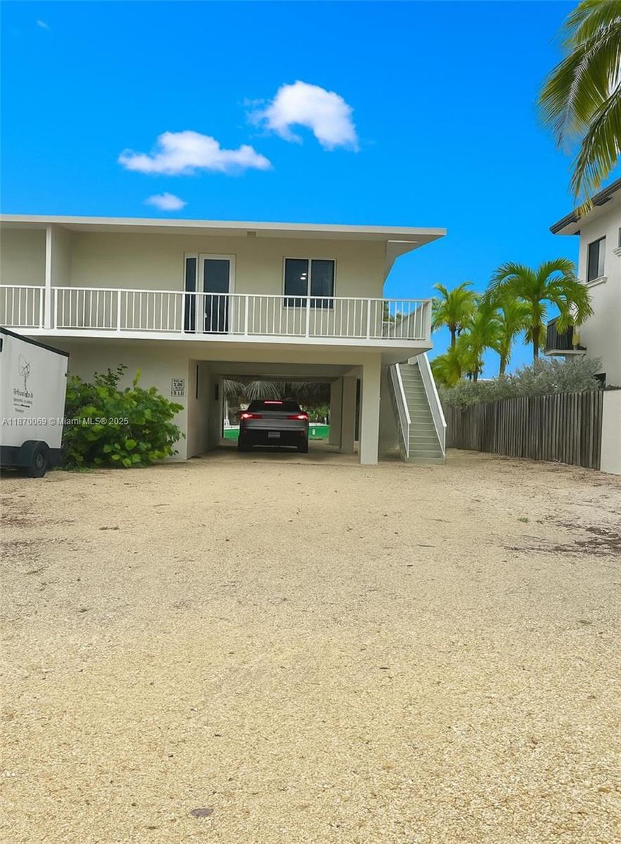 Waterfront 2-Bedroom Getaway in Port Largo! This remodeled home is filled with natural lighting and showcases an open layout, modern kitchen with stainless steel appliances, in-unit laundry, covered parking, and a 12,000 lb boat lift. Enjoy the Keys lifestyle with a tiki hut, fish-cleaning station, tropical landscaping, and exclusive community boat ramp access—just minutes from parks, dining, and all that Key Largo has to offer.