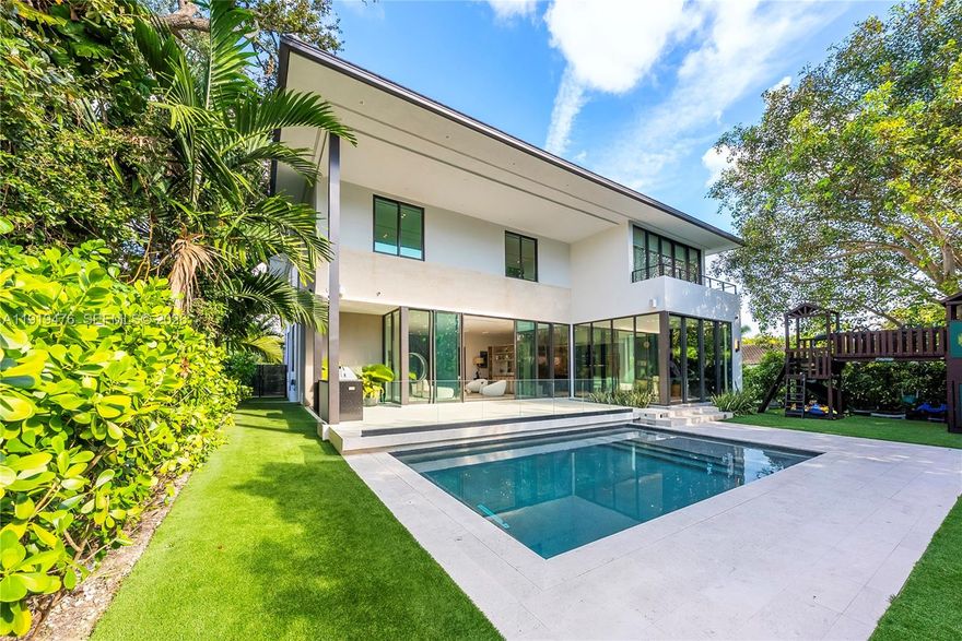 Discover contemporary luxury in this brand-new tranquil Miami Shores estate, where modern sophistication meets family driven comfort. Boasting 6 bedrooms, 5.5 bathrooms, and striking design, this home is a masterpiece. The open-concept layout features soaring 11-foot ceilings, custom millwork, and seamless indoor-outdoor flow through panoramic glass doors. The Mia Cucina kitchen is a chef’s dream, equipped with Wolf and Sub-Zero appliances, sleek cabinetry, and an oversized island. Flexible spaces include two guest rooms downstairs, dual living areas, and a dedicated office. Upstairs, the primary suite offers a private deck, oversized walk-in closet, and spa-like en suite. All four suites upstairs converge around a third media/living room. Outside, enjoy a sparkling pool, summer kitchen, and expansive deck amid lush landscaping. Nestled in coveted Miami Shores, you're moments from dining, shopping, and beaches. This architectural gem is your ultimate retreat—centrally located next to everything Miami has to offer.