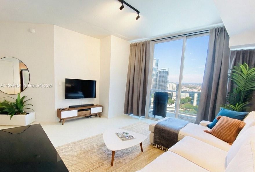 Lovely large 1 bedroom industrial style loft fully furnished and updated.   This modern residence offers amazing views of Biscayne Bay and the city skyline from your private balcony, with cool exposed concrete ceilings, huge floor-to-ceiling windows for tons of natural light, stylish flooring, and an open kitchen featuring stainless steel appliances.   Enjoy resort-style amenities such as infinity pool and hot tub, sauna, steam room, modern fitness center, BBQ areas, business center, 24-hour security and concierge. You’re just steps from Midtown’s top shops, restaurants, and nightlife, with easy walking access to the luxury Design District for shopping and art, and the creative Wynwood Arts District for galleries and street art—plus quick connections to Downtown, the beach, and major highways. Don’t miss this fantastic opportunity in one of Miami’s most exciting neighborhoods