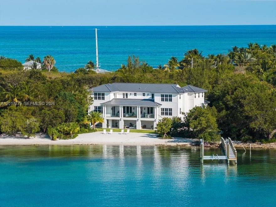 LUXURY BEACHFRONT ESTATE HOME! Come embrace this brand-new magnificent property where you will encounter a relaxing ambiance gracefully set on over 2 private acres of pristine bayfront offering deep-water dockage with a 20,000 lb boat lift, a  white sandy beach and stunning unobstructed panoramic views of the Florida Bay located in desirable Lower Matecumbe. Spanning nearly 6,000 square feet of extraordinary living space with 7 bedrooms and 7 bathrooms. Thoughtfully designed for ultimate comfort, this estate features two separate guest wings, each offering three private bedroom suites, ideal for family, guests or an unparalleled private retreat. The gourmet chef's kitchen, perfect for entertaining, leads to an expansive and inviting great room, elegant tray ceilings, designer finishes, and sophisticated architectural details throughout. A private elevator offers effortless access between levels.
Step outside to your own tropical sanctuary, where a stunning pool deck overlooks the sparkling waters of Florida Bay. Lush tropical landscaping provides privacy, while spacious covered terraces provide the perfect backdrop for unforgettable sunsets and year-round outdoor living.
With weekly rentals permitted and a valuable vacation rental license in place, this rare offering combines luxurious personal enjoyment with outstanding investment potential. Experience the Florida Keys lifestyle in one of Lower Matecumbe's most exclusive waterfront settings.