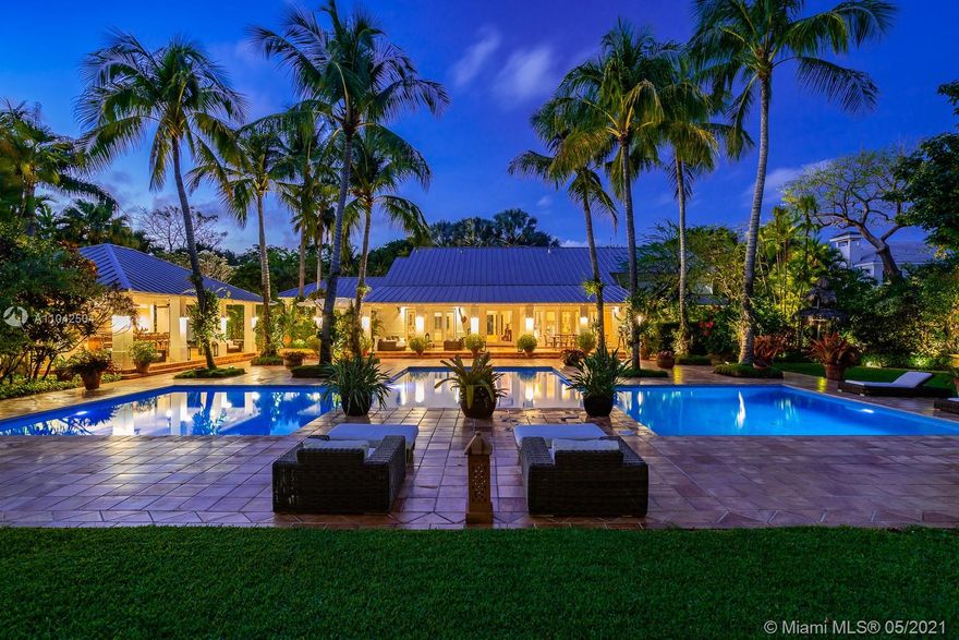 Fall in love with this extraordinary estate that is the essence of South Florida living. Magnificent interiors and splendid al fresco spaces are nestled in a vibrant flora of striking exotics. Volume ceilings, walls of glass, and splendid grass cloth coverings are the backdrop to grand social spaces which include a huge eat-in kitchen, family room w/ 1200+ bottle wine cellar, and fabulous living & dining rms. Bedrooms are glorious; each w/ ensuite bath, and the master suite is a divine spa in itself.The crown jewel of this paradise is the outdoor oasis of covered verandas, resort-style pool, remarkable summer kitchen, and breathtaking canopy of color. One could never imagine what lies beyond these gates, and PS, there is a 3-car garage w/ air-conditioned gym and a full house generator too!