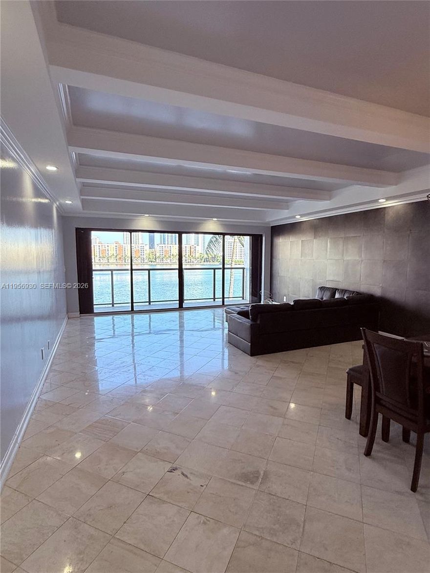 Experience waterfront living in the prestigious gated community of Eastern Shores. This stunning penthouse residence in the sought-after Pelican Landing community boasts direct Intracoastal frontage and breathtaking water views. The light-filled interior offers a spacious layout with a seamless flow between the living and dining areas, leading to a generous terrace perfect for unwinding and watching boats glide by.
The updated kitchen is designed for modern convenience, and the unit includes a washer/dryer for added ease. The primary bathroom features a relaxing tub and a separate shower. This partially furnished residence is situated in an elevator building with a gym and pool and also includes two covered parking spaces. Enjoy the benefits of a gated community, conveniently located near shopping, dining, Oleta River State Park, and the pristine beaches of Sunny Isles.