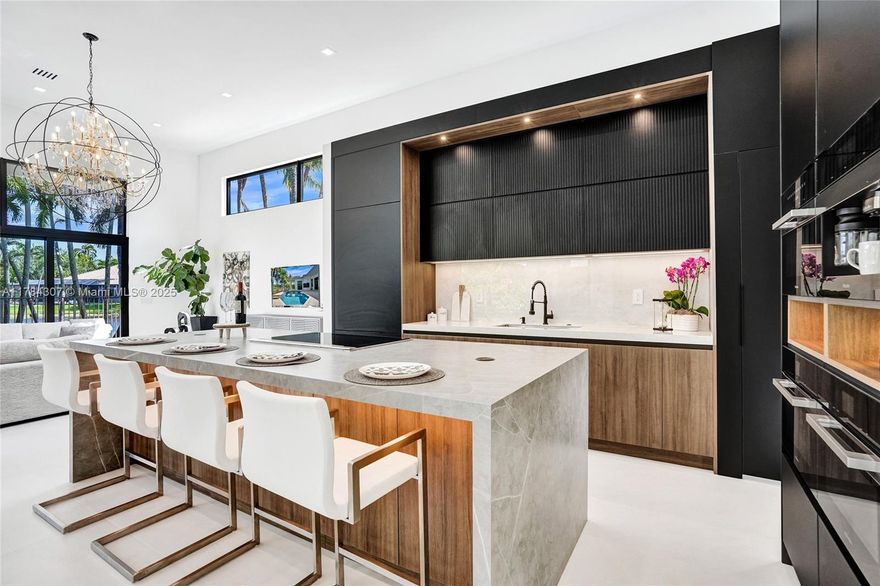 Discover this fully renovated estate in Poinciana at Weston Hills CC situated on a 16,345 sqft lot. Every inch of this home showcases exceptional craftsmanship, including NEW impact windows, NEW roof, and NEW HVAC system. Inside, 4 Bedrooms/Office/4.5 Bath, floor-to-ceiling windows flood open-concept layout with natural light, water and pool views. Gourmet kitchen with Miele/Wolf appliances, Neolith stone surfaces, Italian Marfa cabinetry, and spacious hidden pantry. Modern 50-bottle glass wine cellar with 8ft glass pivot door and European hardwood. Retreat to oversized primary suite, with boutique-style closet and spa like bathroom, while all-new “Belldini” solid core doors. Outside, resort-style pool with Diamond Brite, paver deck, and covered patio overlooking the panoramic lake views.