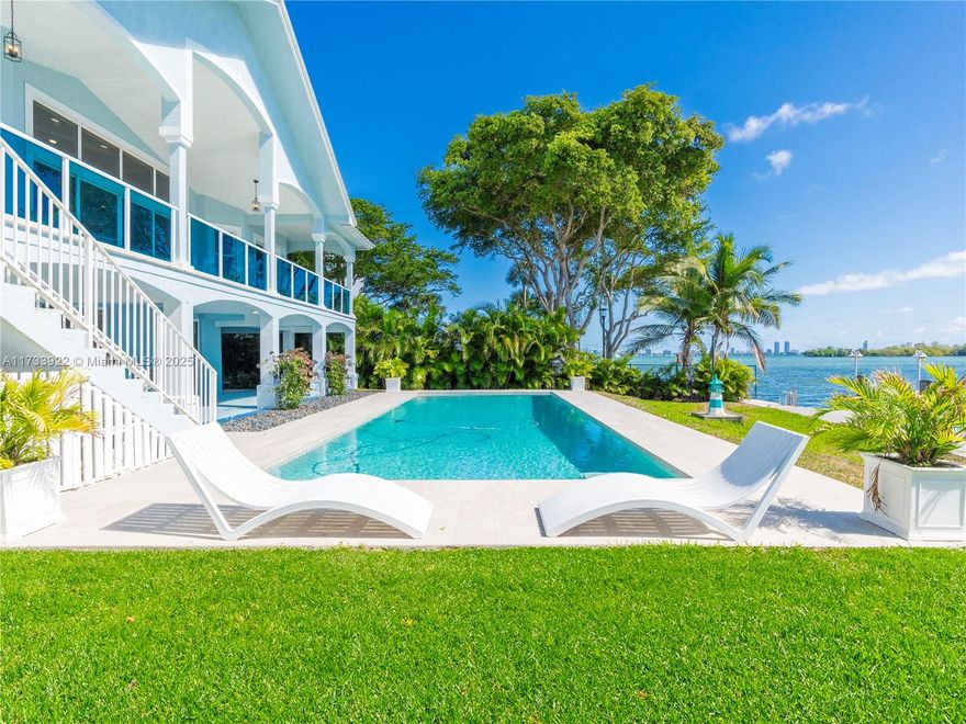 This premier waterfront estate offers 120 feet of direct Biscayne Bay frontage with no fixed bridges, featuring a private dock for up to an 80-foot yacht. Nestled on a lushly landscaped 12,816 sqft lot, this Florida Keys-style home boasts an expansive patio, a spacious pool, and breathtaking water views. Inside, the open floor plan is enhanced by soaring volume ceilings and a stunning 25-foot skylight. Designed for entertainment, the home includes a large media room, ground level open patio space leading to the pool, an elevator for convenience, and a separate guest quarters complete with full bath. This home is ideally located near top schools, fine dining, within close proximity to Miami Beach, this is a true paradise for boaters & water lovers alike.