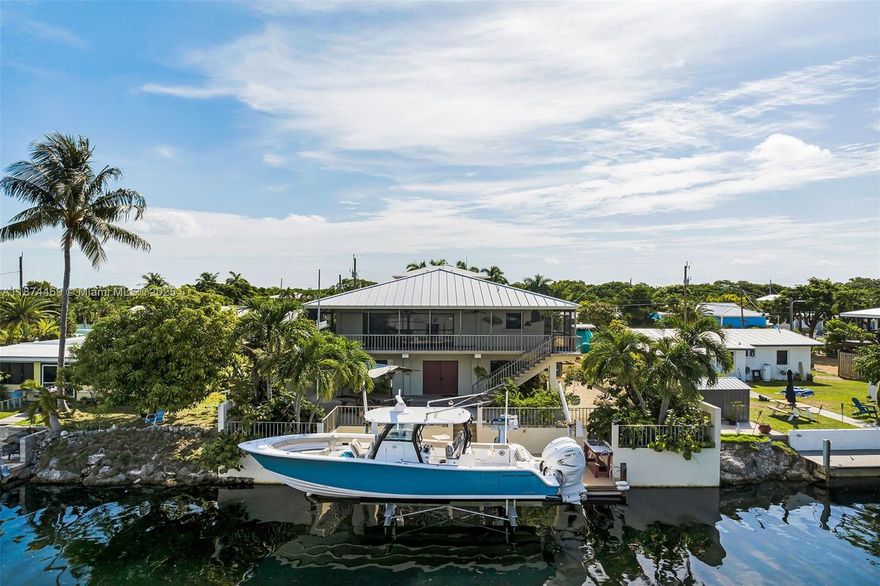 Your Florida Keys escape awaits in Marathon with stunning water views and premier boating amenities. This stilt home blends comfort, charm, and investment potential, featuring an open layout filled with natural light, screened-in balcony and patio, Gulf views, metal roof, and accordion shutters. Enjoy direct Gulf access via a wide, deep flow-through canal, 60-ft concrete dock, brand-new 25,000 lb. boat lift with davits, fish cleaning station, full RV hookups, and space to add a pool. The garage offers storage, water filtration, ice machine, and an extra room for a workshop, storage, or flex space. Licensed as a 7-day vacation rental with strong history, this is a complete Florida Keys package, with a negotiable boat and commercial flights coming to Marathon