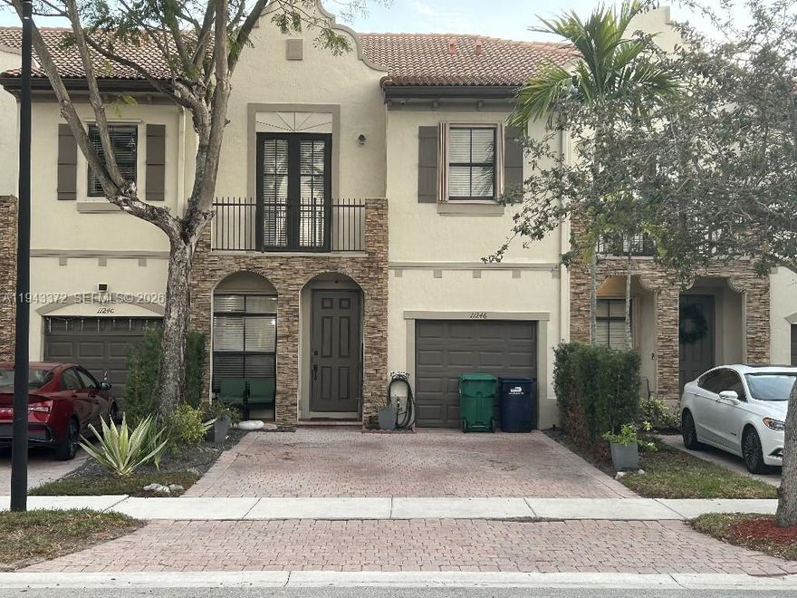 This elegant townhome features beautiful designer exterior stone, decorative accent details with accordian shutters and impact balcony doors, brick paver driveway and iconic Spanish-style roof. Includes a one-car garage, wood finish cabinetry in kitchen with stainless steal appliances and granite countertops, crown moldings, wood staircase with iron railings, tiled floors throughout, covered large patio fully paved ideal for entertaining and outdoor cooking. You can enjoy a stroll through the many winding streetscapes; entertain outdoors at the parks and BBQ pavilion, and indoors in the private party room. Also includes a resort-style clubhouse, oversized pool and spa, kids' water park, fitness room with saunas and full basketball court. A Must See!