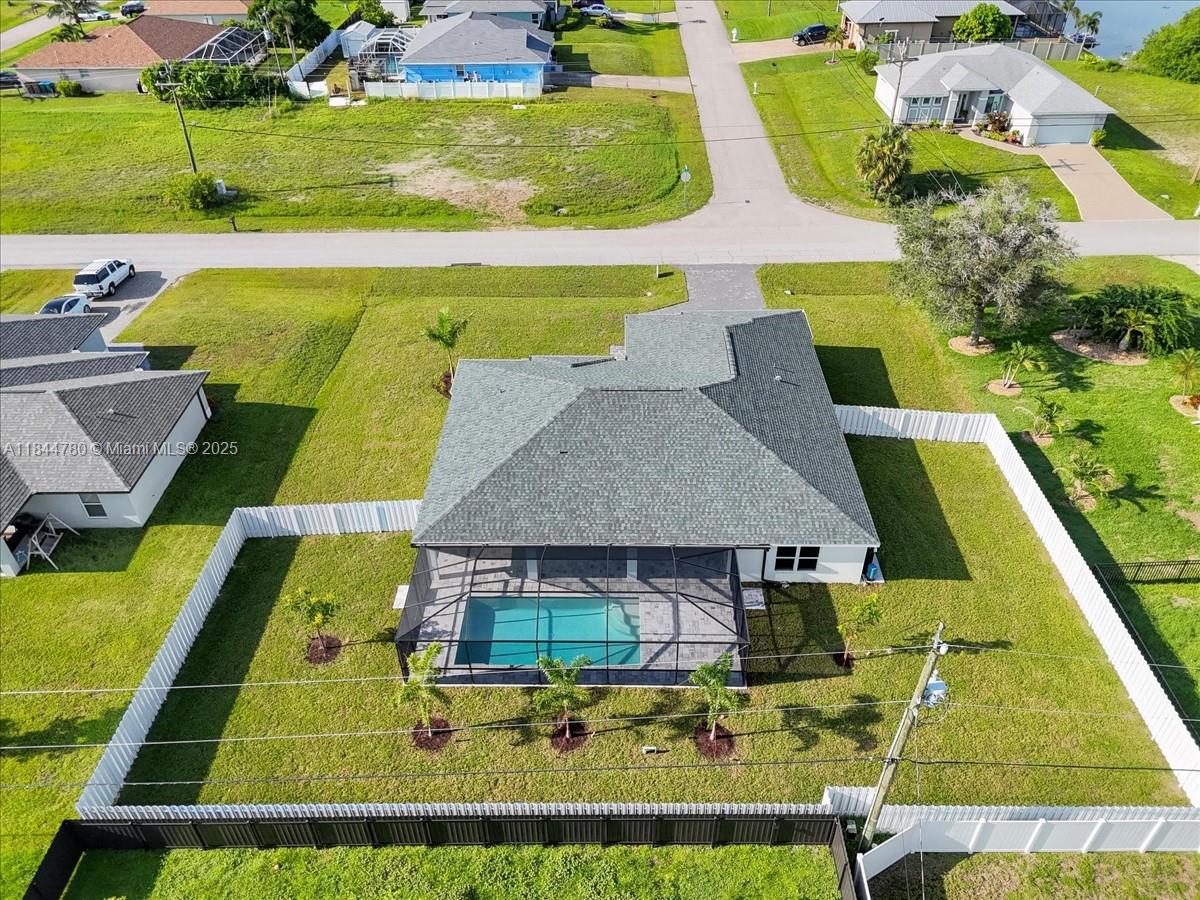 $15,000 BUILDER PAID CLOSING COSTS! HUGE TRIPLE LOT WITH PLENTY OF ROOM FOR BOATS AND TOYS!! SPACIOUS SCREENED-IN POOL HOME WITH A PRIVACY FENCE AND DUAL PRIMARY SUITES! This Spacious Pool Home features 4 large beds, 3 baths, Two Primary Suites! Step inside and experience the open-concept great room, highlighted by a 12-foot triple slider that seamlessly connects indoor living to the expansive lanai and heated pool. Gourmet kitchen is a chef’s delight with walk-in pantry. Built by a trusted local builder, this home offers incredible value in Cape Coral. Plus, enjoy peace of mind with a 10-year structural warranty, NO FLOOD ZONE + IMPACT WINDOWS = LOW INSURANCE COSTS. This is The Paradise Cove Plan.