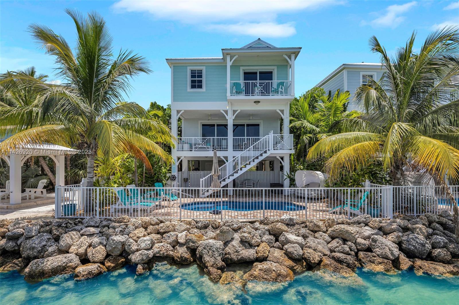 Maintenance free 5 bedroom single family, pool-home on Vaca Cut with incredible open water views! This unbeatable location awards you with instant access to both the Ocean & the Bay from its 36 ft. deep water dock. Built for modern living, its professionally designed interior boasts a gorgeous quartz kitchen with waterfall island, a gas range (rare in the Keys), 7 inch baseboards, luxury vinyl plank flooring and a wealth of water views that can be enjoyed from one of the numerous tiled porches. Hurricane impact windows and doors encompass this 2020 concrete home, creating quiet and efficient living! Nestled in a gated community which offers a waterfront gazebo, dog walk and perfectly maintained landscaping & pools both managed by the HOA, ensuring this 9 home community stays pristine!