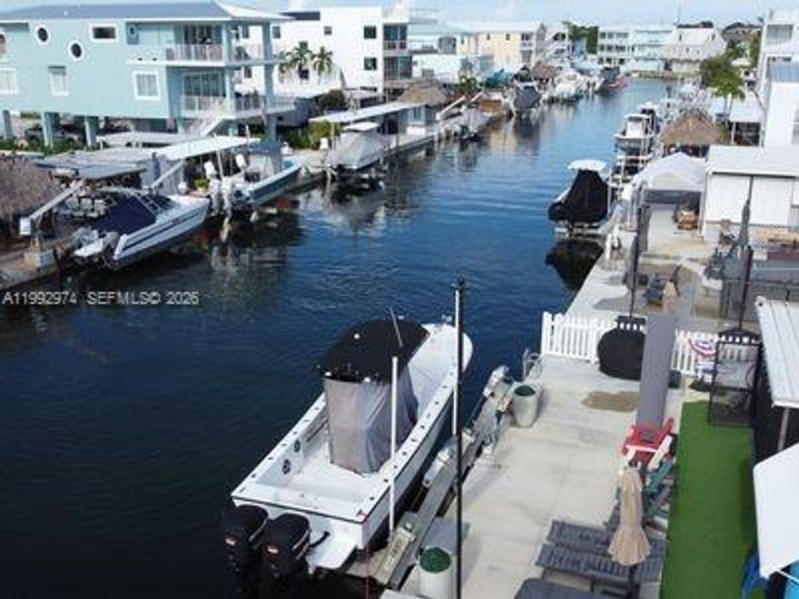 Step into your slice of paradise with this Key Largo home, featuring all-tile floors--perfect for hosting guests or creating your own private retreat. Relax and unwind on the screened patio, or take in the serene water views along the extra-wide canal. Boating enthusiasts will love the 40 feet of private dock space with a 12,000 lb boat lift, offering direct and easy access to the open waters of the Florida Keys. After a day on the water, enjoy the soothing outdoor jacuzzi for the ultimate Keys-style relaxation. Whether you're seeking a full-time residence, vacation getaway, or investment opportunity, this home captures the essence of island living. Come experience the peace, beauty, and charm that make this property a true heaven in the Keys. Realtor is owner of property.