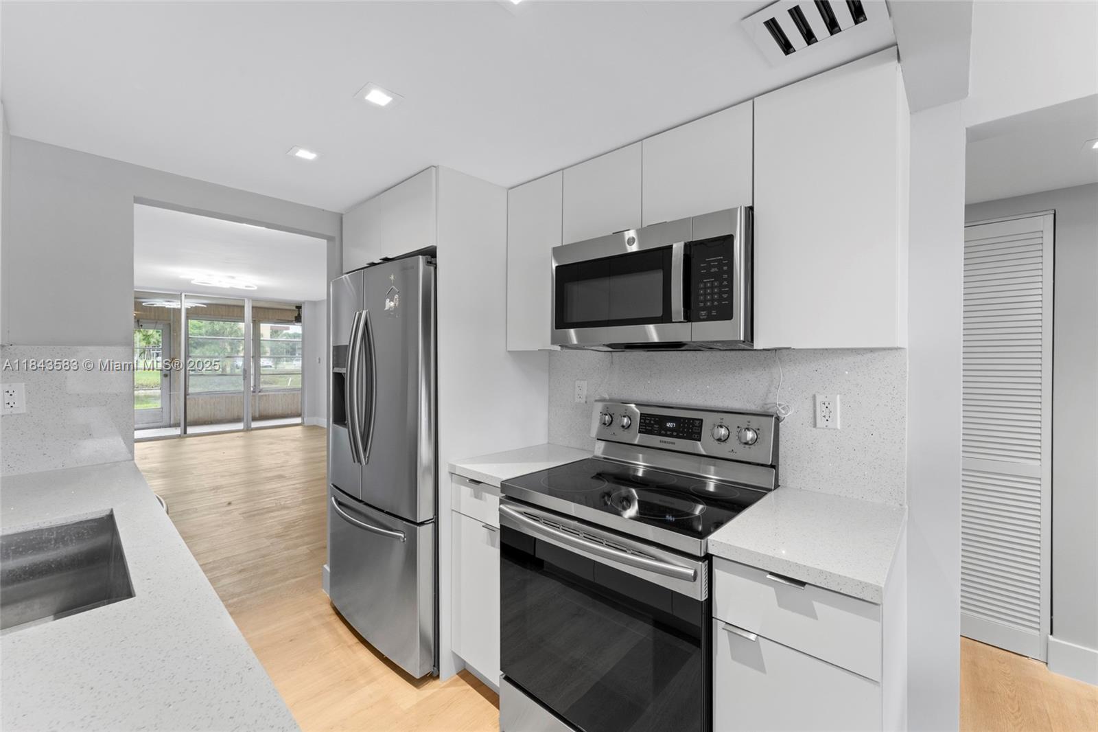 Experience this beautifully renovated 2-bedroom, 2-bath first-floor condo where no detail was overlooked. Everything is new—from floors to ceilings. The open layout was redesigned with premium finishes and high-end appliances in a sleek kitchen. Enjoy new flooring, modern bathrooms with custom tile work, and a private washer and dryer. The spacious primary bedroom includes a walk-in closet, with ample storage throughout the unit. A bright laundry/utility area with glass enclosure overlooks lush greenery. Located in a well-maintained, centrally located community close to shopping, dining, and more.