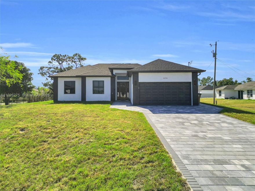 CITY WATER. Seller concessions available. Discover this stunning new-construction single-family home perfectly situated on a quiet cul-de-sac in Lehigh Acres. Sitting on an oversized 0.32-acre lot with city water, this modern residence offers exceptional space, comfort, and convenience. It features three spacious bedrooms, two full bathrooms, and an attached two-car garage. Enjoy an elegant open-concept kitchen with stainless steel appliances, sleek cabinetry, premium finishes, and the added benefit of a washer and dryer already included. Furniture is negotiable, making your move-in experience even easier. Designed with quality in mind, the home showcases high ceilings, impact-resistant windows and doors, and beautiful tile flooring throughout. The luxurious master suite includes two walk-in closets and a spa-inspired bathroom. Step outside and entertain effortlessly in your outdoor kitchen—perfect for year-round Florida living. Ideally located near Lee Blvd, Joel Blvd, Richmond Ave N, and East 10th St, this home provides easy access to shopping, dining, schools, and major routes. A must-see opportunity!