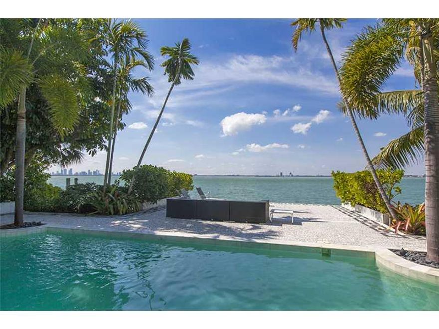 Views of the Bay & downtown Miami. Set back & gated, brick drive w/lush landscaping hides covered walkway to home & courtyard. Picture windows line living area w/bar & separate dining. Kitchen boasts SS appliances, cooking island & butler's pantry. Savor  sunsets from balcony off Master. Master Bath: plenty of storage, spa shower & dual seat tub w/direct bay views. Master features add'l bath, den & walkin closet. Other highlights: full maid's quarters, summer kitchen, Terrazzo floors, office & 2-car garage