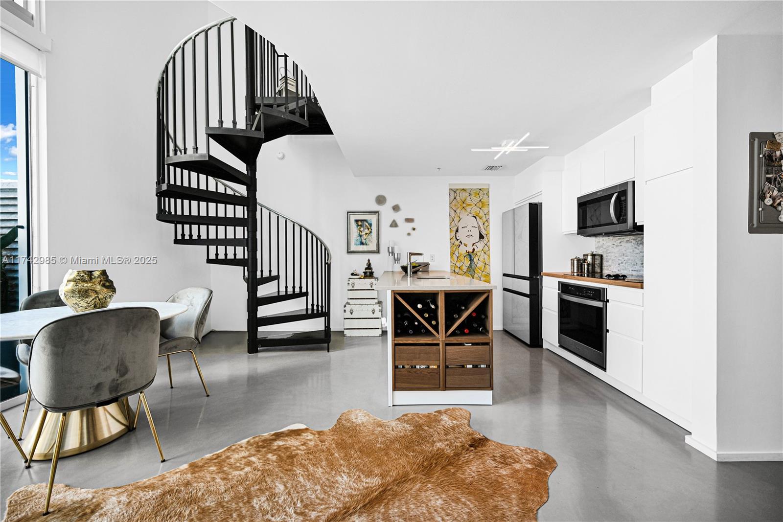 Experience luxury waterfront living in this high end furnished two-story 1-bedroom Loft at MET1, featuring soaring 19'4" ceilings and expensive floor-to-ceiling windows with stunning bay views from all levels. This fully renovated New York loft-style home boasts concrete flooring, a spiral staircase & custom feature walls. The renovated kitchen offers a large peninsula, newer stainless steel appliances, & a hot/cold water filtration system. The spacious bedroom includes a custom walk-in closet & dedicated office space. Motorized window coverings on all windows add convenience. Prime Brickell-adjacent location offers unparalleled urban convenience: near Whole Foods, a luxury cinema, & Bayfront Park. Full-service building with valet, fiber-optic internet, fitness center, EV charging, & more.